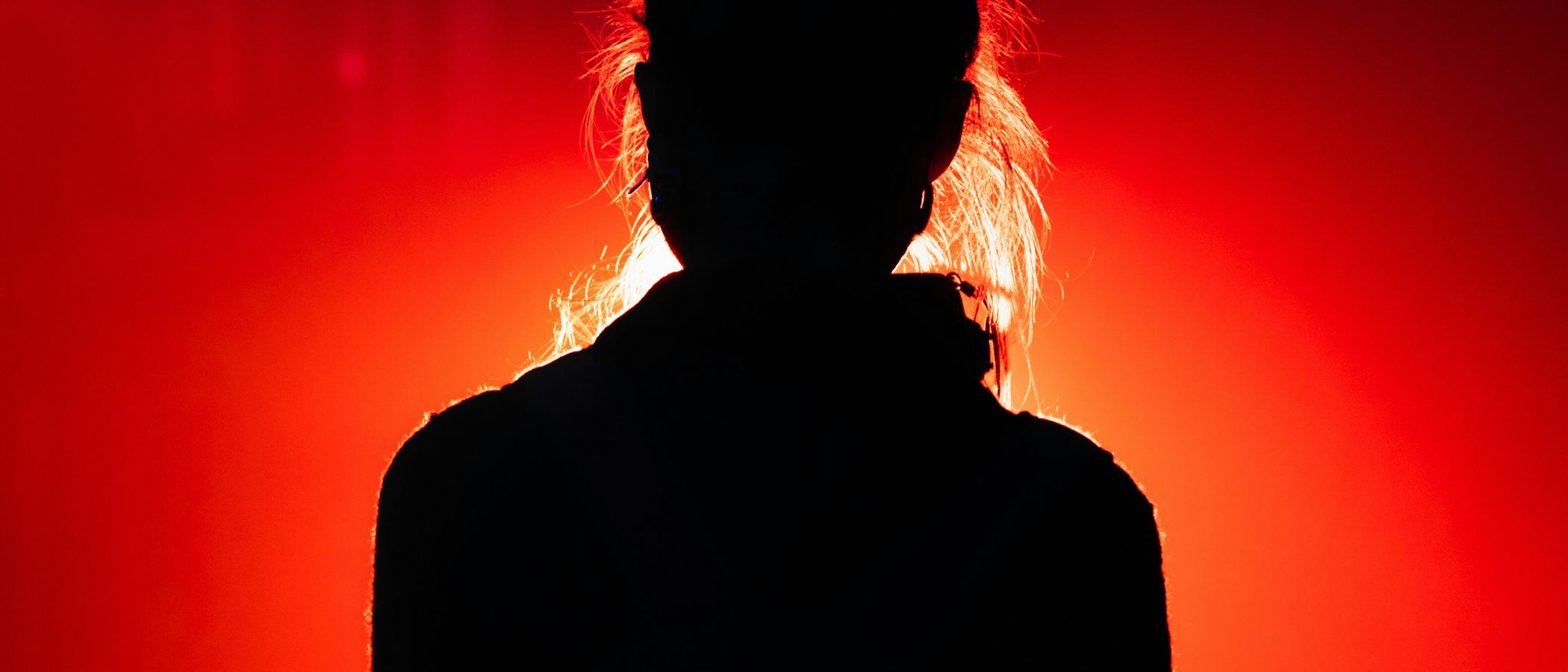 Performer silhouette under red dramatic light
